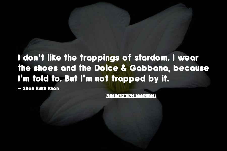 Shah Rukh Khan Quotes: I don't like the trappings of stardom. I wear the shoes and the Dolce & Gabbana, because I'm told to. But I'm not trapped by it.