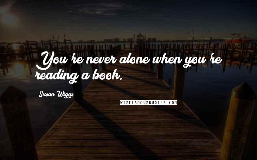 Susan Wiggs Quotes: You're never alone when you're reading a book.