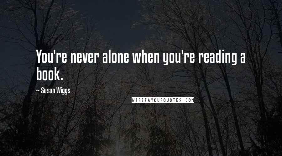Susan Wiggs Quotes: You're never alone when you're reading a book.