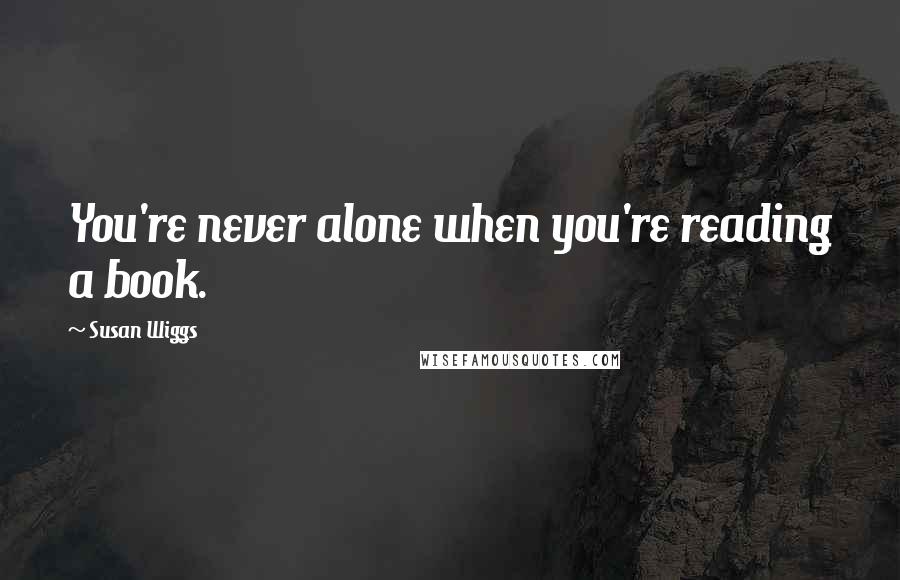 Susan Wiggs Quotes: You're never alone when you're reading a book.