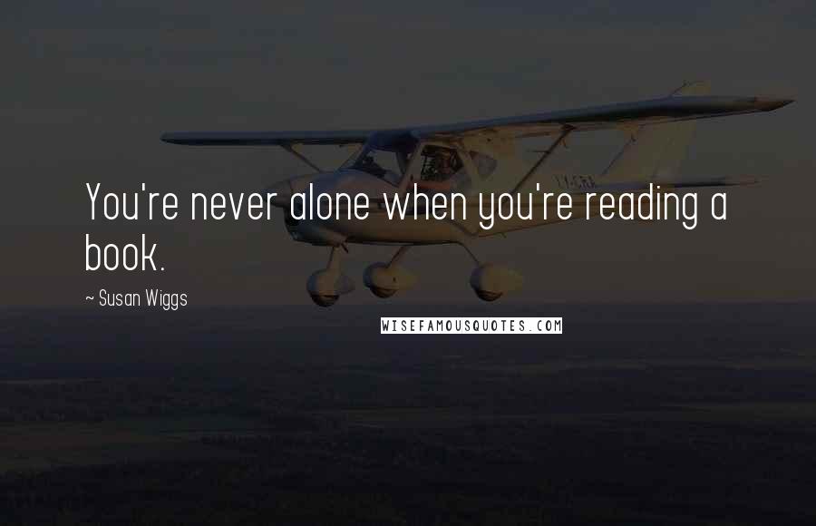 Susan Wiggs Quotes: You're never alone when you're reading a book.