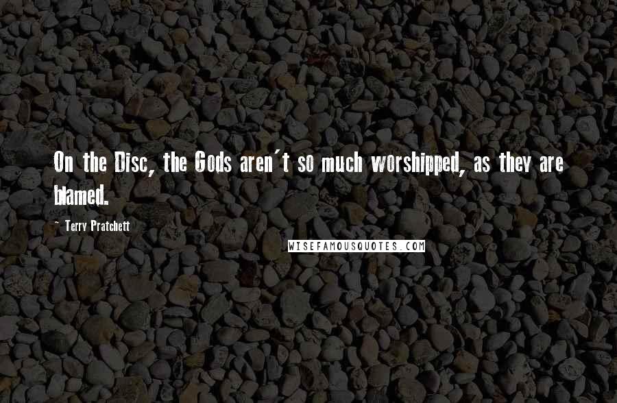 Terry Pratchett Quotes: On the Disc, the Gods aren't so much worshipped, as they are blamed.
