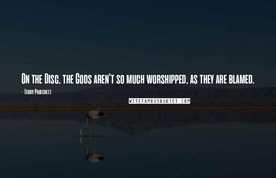 Terry Pratchett Quotes: On the Disc, the Gods aren't so much worshipped, as they are blamed.