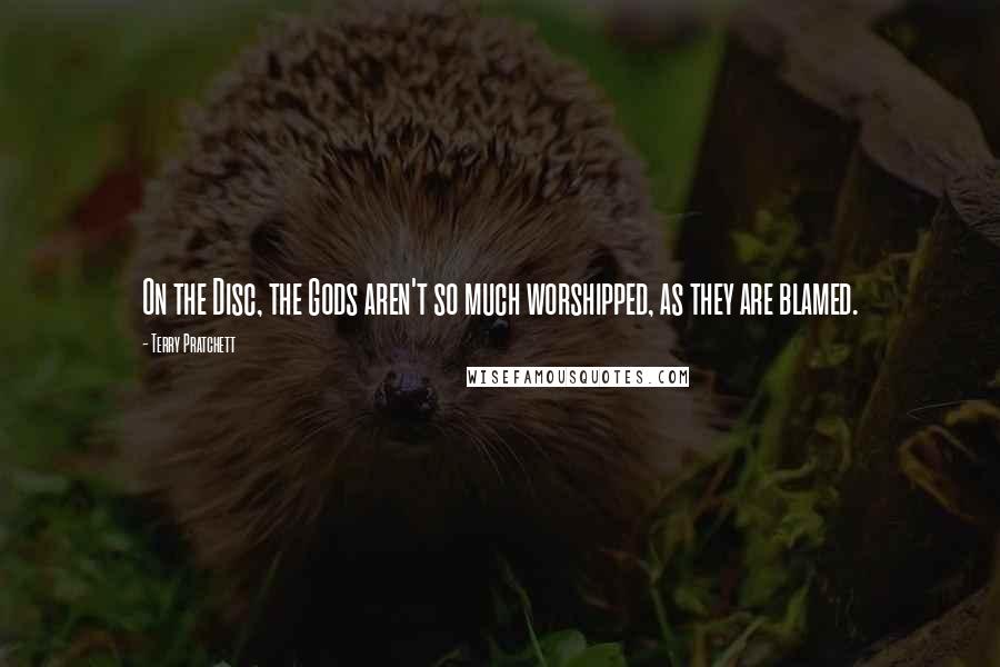 Terry Pratchett Quotes: On the Disc, the Gods aren't so much worshipped, as they are blamed.