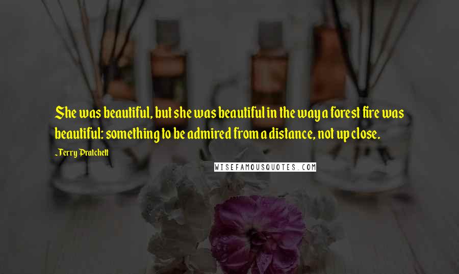 Terry Pratchett Quotes: She was beautiful, but she was beautiful in the way a forest fire was beautiful: something to be admired from a distance, not up close.