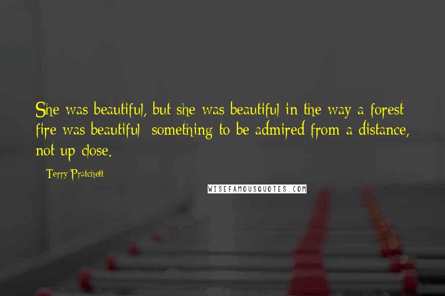 Terry Pratchett Quotes: She was beautiful, but she was beautiful in the way a forest fire was beautiful: something to be admired from a distance, not up close.