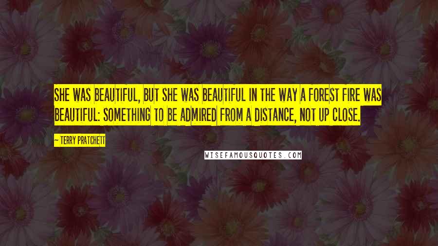 Terry Pratchett Quotes: She was beautiful, but she was beautiful in the way a forest fire was beautiful: something to be admired from a distance, not up close.