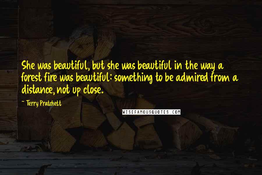 Terry Pratchett Quotes: She was beautiful, but she was beautiful in the way a forest fire was beautiful: something to be admired from a distance, not up close.
