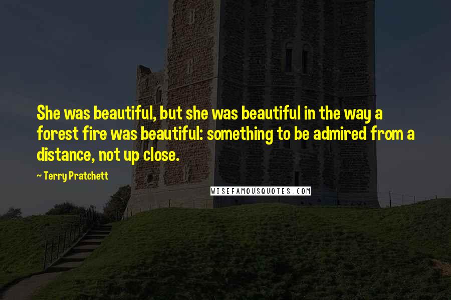 Terry Pratchett Quotes: She was beautiful, but she was beautiful in the way a forest fire was beautiful: something to be admired from a distance, not up close.