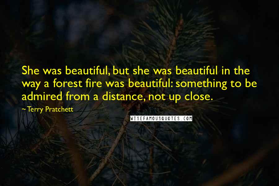 Terry Pratchett Quotes: She was beautiful, but she was beautiful in the way a forest fire was beautiful: something to be admired from a distance, not up close.