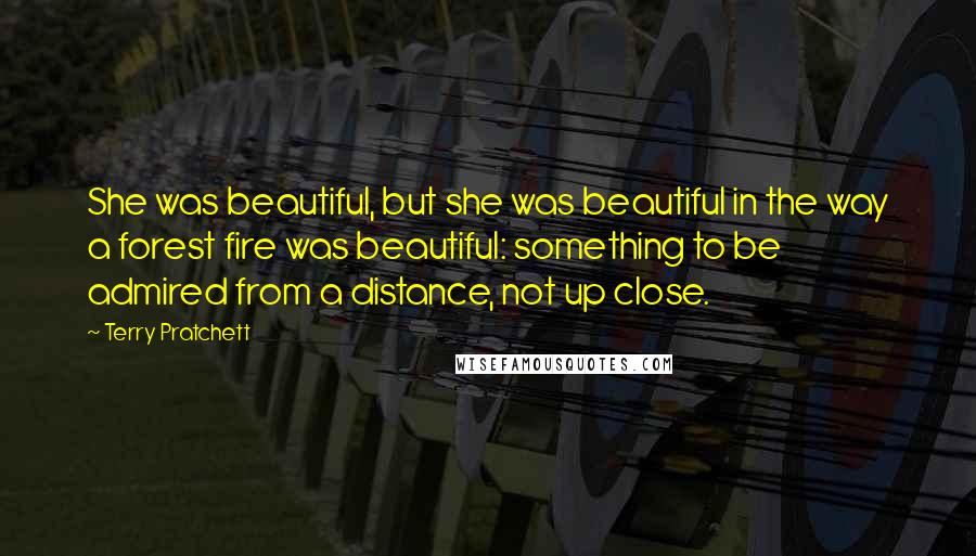 Terry Pratchett Quotes: She was beautiful, but she was beautiful in the way a forest fire was beautiful: something to be admired from a distance, not up close.
