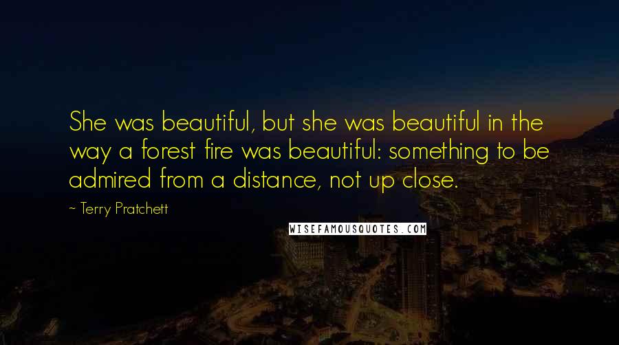 Terry Pratchett Quotes: She was beautiful, but she was beautiful in the way a forest fire was beautiful: something to be admired from a distance, not up close.