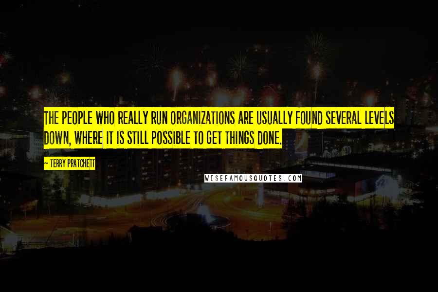Terry Pratchett Quotes: The people who really run organizations are usually found several levels down, where it is still possible to get things done.