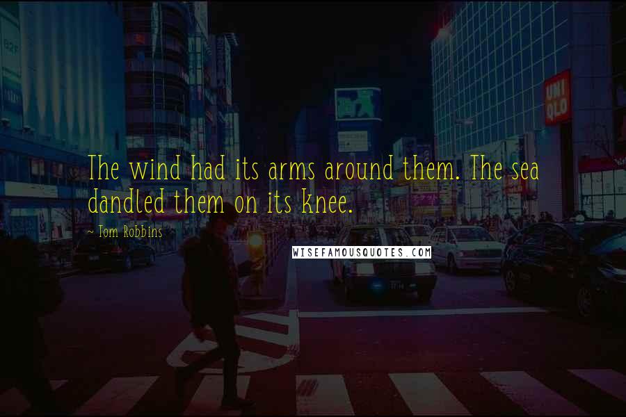 Tom Robbins Quotes: The wind had its arms around them. The sea dandled them on its knee.