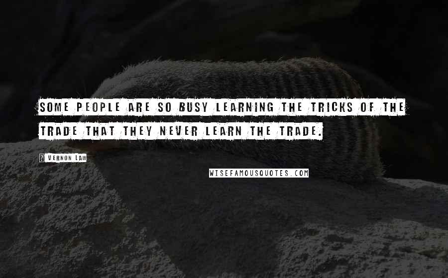 Vernon Law Quotes: Some people are so busy learning the tricks of the trade that they never learn the trade.