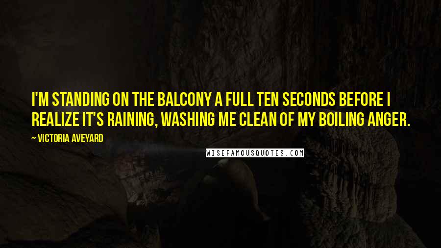 Victoria Aveyard Quotes: I'm standing on the balcony a full ten seconds before I realize it's raining, washing me clean of my boiling anger.