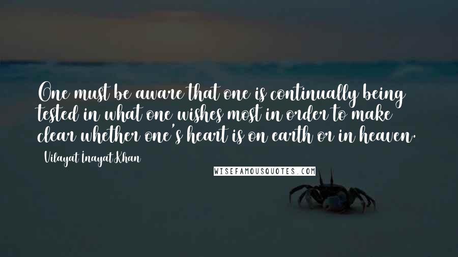 Vilayat Inayat Khan Quotes: One must be aware that one is continually being tested in what one wishes most in order to make clear whether one's heart is on earth or in heaven.