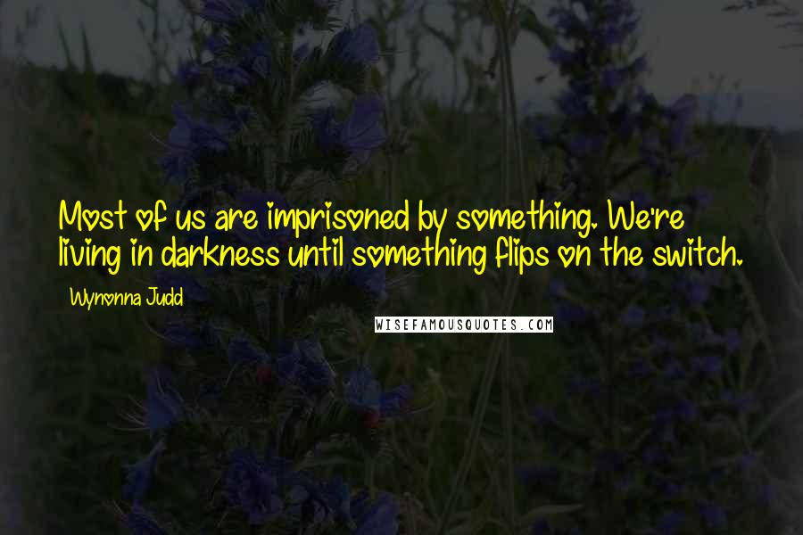 Wynonna Judd Quotes: Most of us are imprisoned by something. We're living in darkness until something flips on the switch.