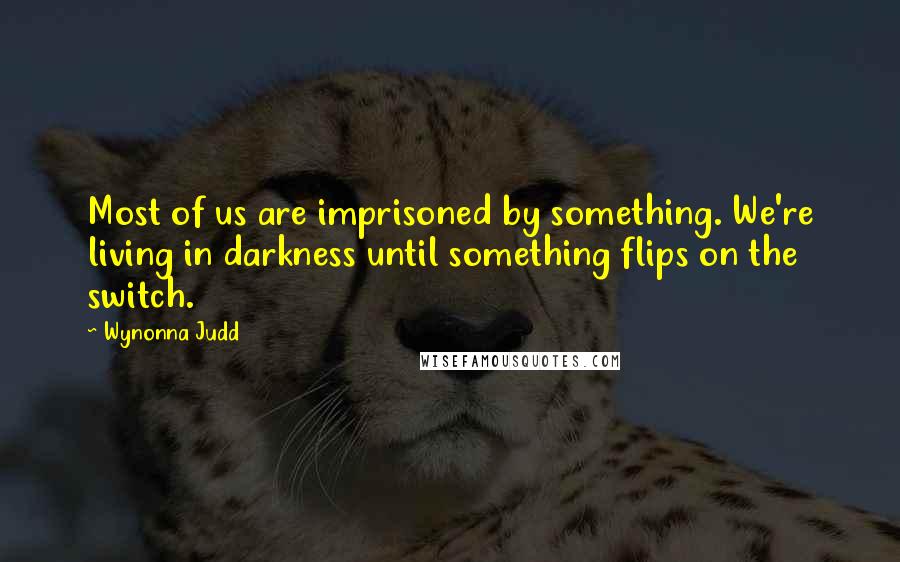 Wynonna Judd Quotes: Most of us are imprisoned by something. We're living in darkness until something flips on the switch.
