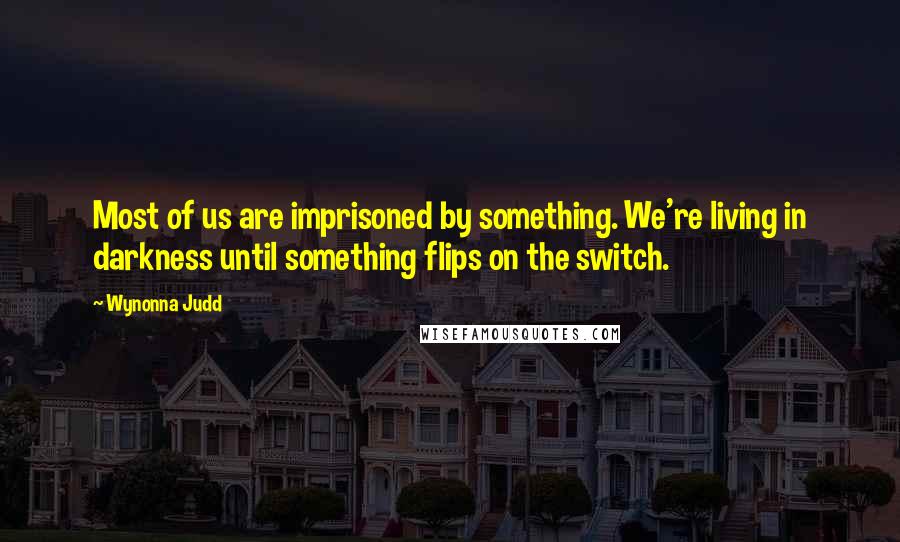 Wynonna Judd Quotes: Most of us are imprisoned by something. We're living in darkness until something flips on the switch.