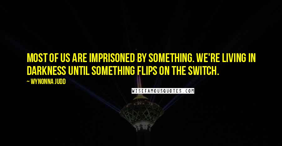 Wynonna Judd Quotes: Most of us are imprisoned by something. We're living in darkness until something flips on the switch.